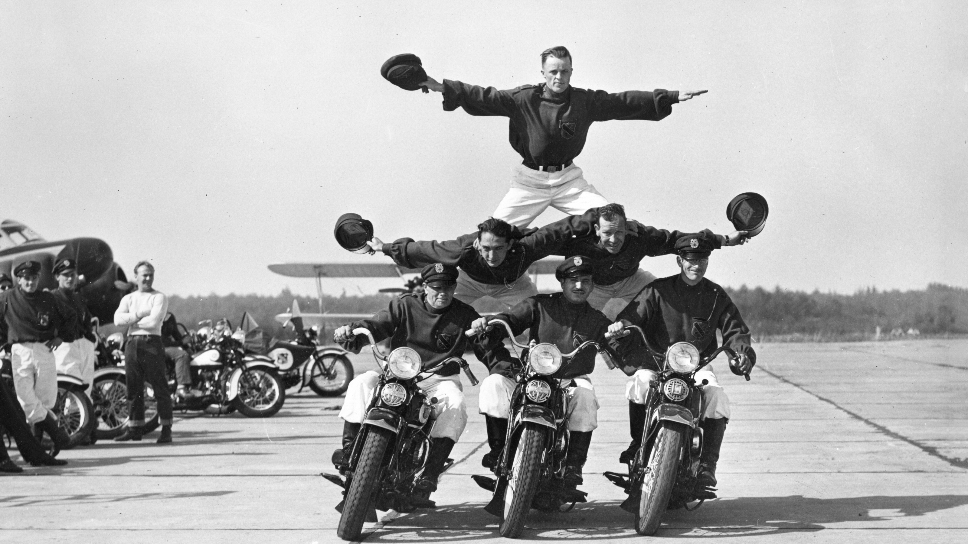 Six members of the Seattle Cossacks Stunt and Drill Team form a pyramid while riding three motorcycles.